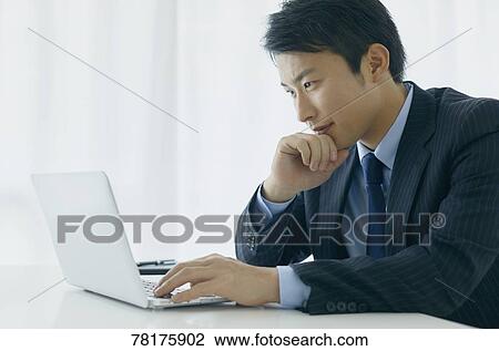 Stock Image - Japanese businessman working. Fotosearch