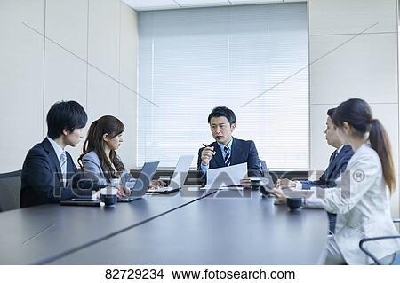 Picture - Japanese businesspeople in a meeting. Fotosearch