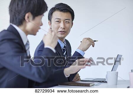 Picture - Japanese businesspeople in a meeting. Fotosearch