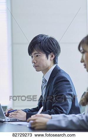 Stock Image - Japanese businesspeople in a meeting. Fotosearch