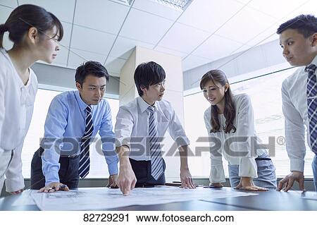Stock Image - Japanese businesspeople in a meeting. Fotosearch
