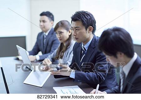 Stock Image - Japanese businesspeople in a meeting. Fotosearch