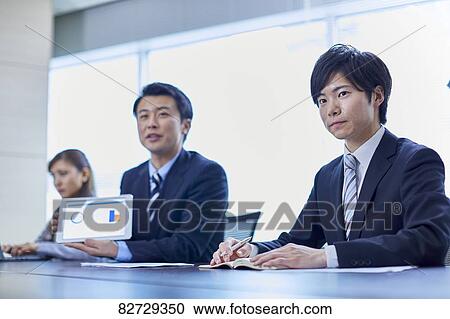 Stock Image - Japanese businesspeople in a meeting. Fotosearch