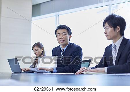 Stock Image - Japanese businesspeople in a meeting. Fotosearch