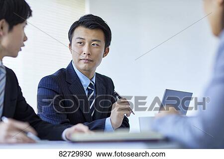 Stock Image - Japanese businesspeople in a meeting. Fotosearch