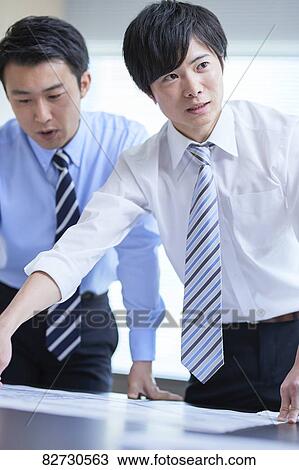 Stock Image - Japanese businesspeople in a meeting. Fotosearch