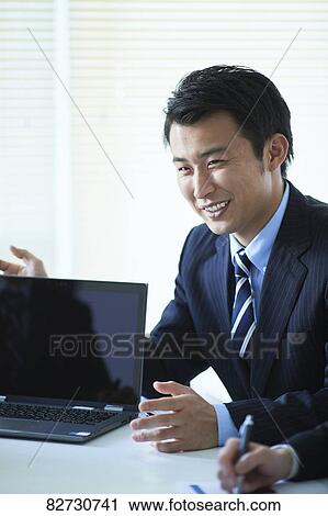 Stock Image - Japanese businesspeople in a meeting. Fotosearch