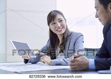 Stock Photograph - Japanese businesspeople in a meeting. Fotosearch