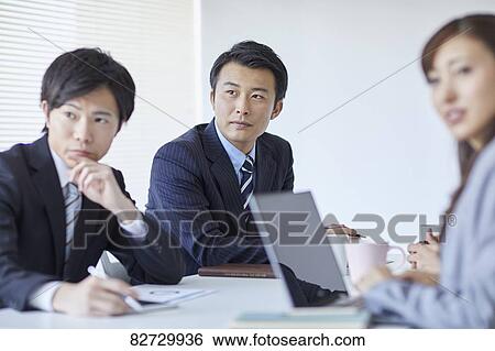 Stock Photograph - Japanese businesspeople in a meeting. Fotosearch