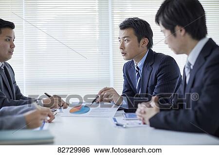 Stock Photograph - Japanese businesspeople in a meeting. Fotosearch