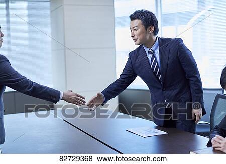 Stock Photo - Japanese businesspeople shaking hands. Fotosearch