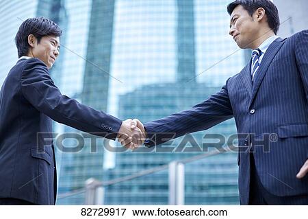 Japanese businesspeople shaking hands downtown Tokyo View Large Photo Image Stock Photo - Japanese businesspeople shaking hands downtown Tokyo. Fotosearch