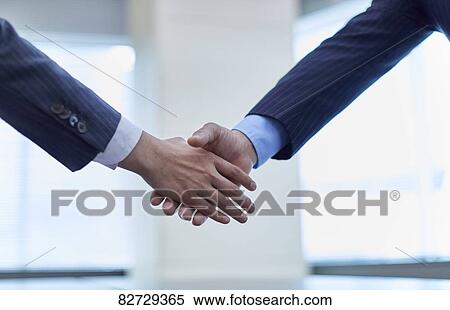 Stock Photography - Japanese businesspeople shaking hands. Fotosearch