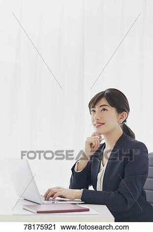 Stock Image - Japanese businesswoman working. Fotosearch