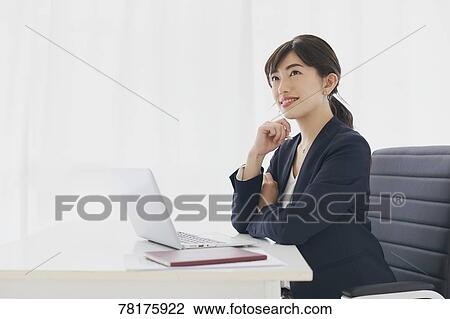 Stock Image - Japanese businesswoman working. Fotosearch