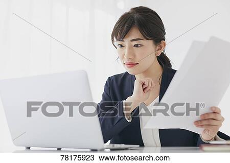 Stock Image - Japanese businesswoman working. Fotosearch