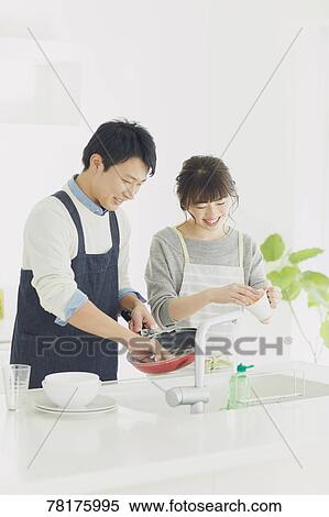 Stock Photography - Japanese couple cooking in the kitchen. Fotosearch