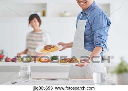 Japanese couple cooking together in the kitchen View Large Photo Image Stock Image - Japanese couple cooking together in the kitchen. Fotosearch