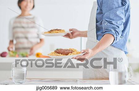 Japanese couple cooking together in the kitchen View Large Photo Image Stock Photo - Japanese couple cooking together in the kitchen. Fotosearch