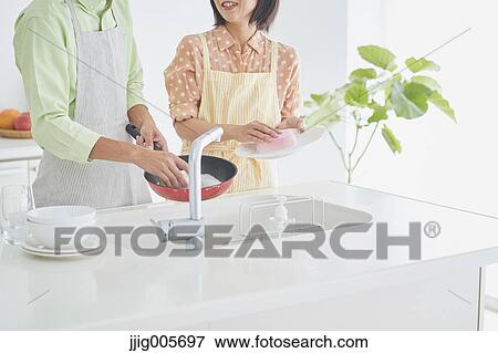 Japanese couple cooking together in the kitchen View Large Photo Image Stock Photo - Japanese couple cooking together in the kitchen. Fotosearch