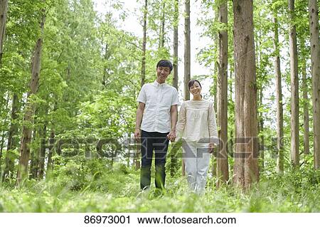 Stock Image - Japanese couple in a city park. Fotosearch