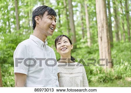 Stock Image - Japanese couple in a city park. Fotosearch
