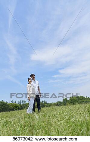 Stock Image - Japanese couple in a city park. Fotosearch