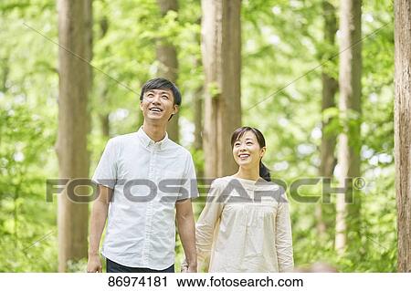 Stock Image - Japanese couple in a city park. Fotosearch