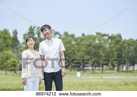 Stock Image - Japanese couple in a city park. Fotosearch