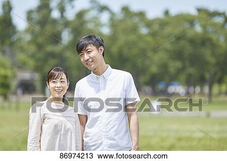 Stock Image - Japanese couple in a city park. Fotosearch