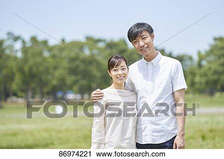 Stock Image - Japanese couple in a city park. Fotosearch