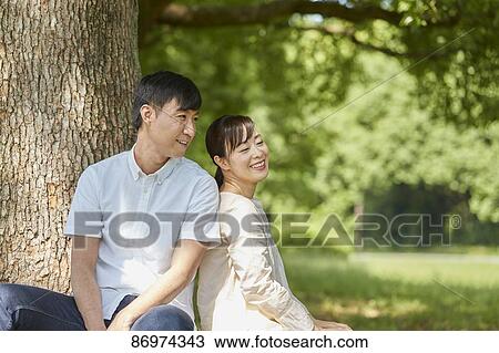 Stock Image - Japanese couple in a city park. Fotosearch
