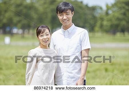 Stock Photo - Japanese couple in a city park. Fotosearch