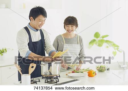 Picture - Japanese couple in the kitchen. Fotosearch