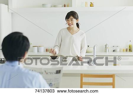 Stock Image - Japanese couple in the kitchen. Fotosearch