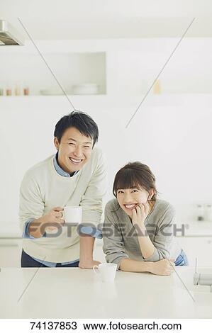Stock Image - Japanese couple in the kitchen. Fotosearch