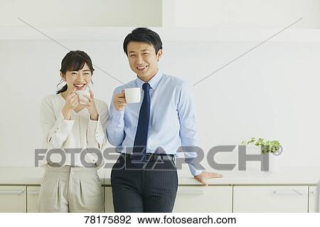 Stock Image - Japanese couple in the kitchen. Fotosearch