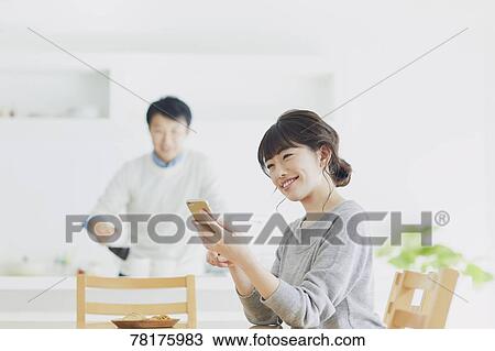 Stock Image - Japanese couple in the kitchen. Fotosearch