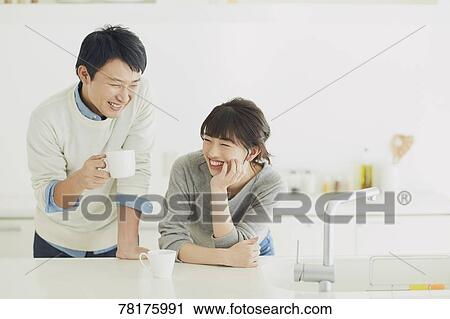 Stock Image - Japanese couple in the kitchen. Fotosearch