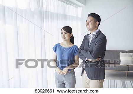 Stock Image - Japanese couple in the living room. Fotosearch