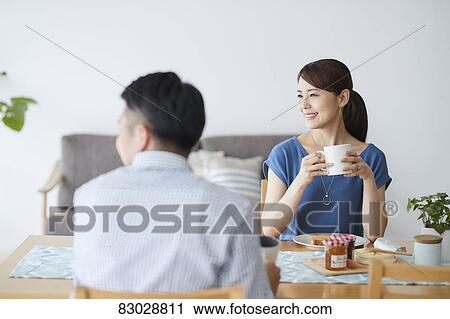 Stock Image - Japanese couple in the living room. Fotosearch