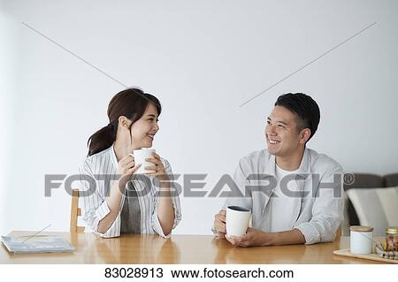 Stock Image - Japanese couple in the living room. Fotosearch