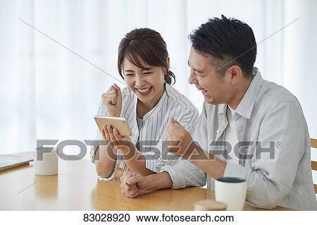 Stock Image - Japanese couple in the living room. Fotosearch