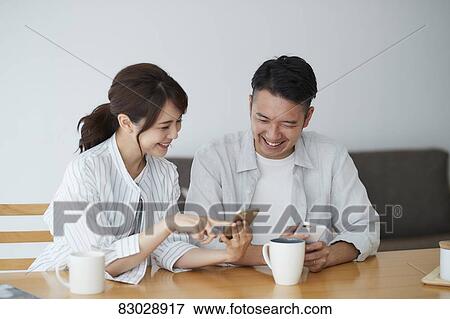 Stock Photo - Japanese couple in the living room. Fotosearch