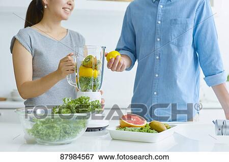 Japanese couple making smoothie in the kitchen View Large Photo Image Stock Photo - Japanese couple making smoothie in the kitchen. Fotosearch