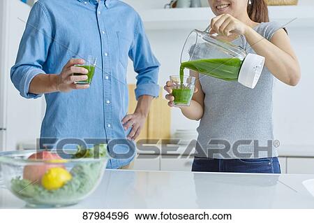 Stock Photograph - Japanese couple making smoothie in the kitchen. Fotosearch