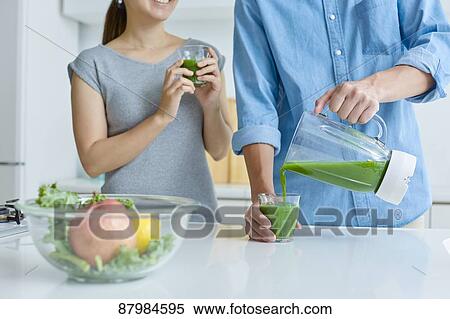 Stock Photography - Japanese couple making smoothie in the kitchen. Fotosearch