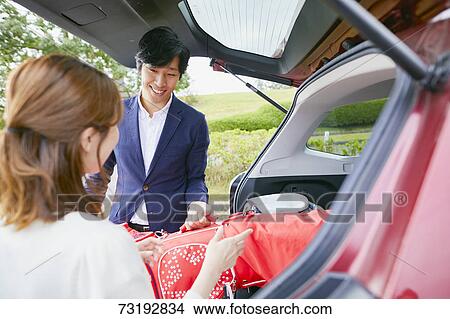 Picture - Japanese couple preparing to play golf. Fotosearch