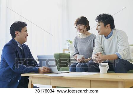 Picture - Japanese couple talking with salesman. Fotosearch