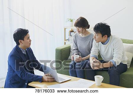 Stock Image - Japanese couple talking with salesman. Fotosearch